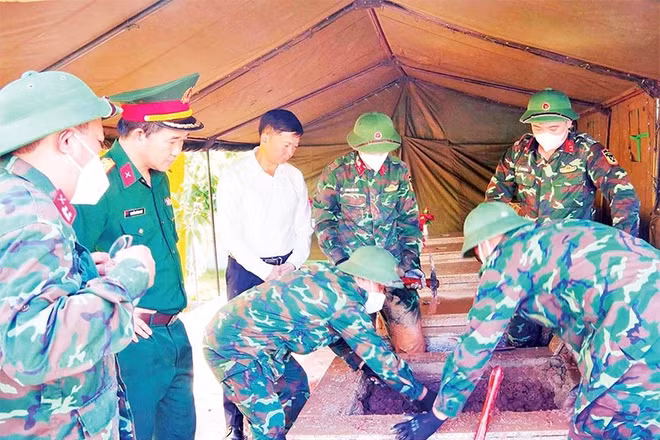 Lực lượng quân sự khai quật mộ phần tại Nghĩa trang liệt sĩ Đình Lập để tiến hành lấy mẫu (Ảnh DƯƠNG NGUYÊN)