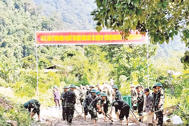 Cán bộ, chiến sĩ Trung đoàn 148 giúp người dân xã Yên Hoa làm đường bê-tông nông thôn.
