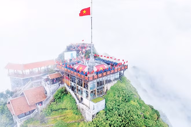 Đoàn viên, thanh niên cùng thực hiện nghi thức chào cờ, hát Quốc ca trên đỉnh núi cao nhất nằm ở trung tâm dãy Hoàng Liên Sơn. 