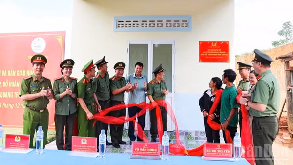 Lãnh đạo Công an tỉnh Khánh Hòa cùng gia đình chị Cao Thị Muỗi thực hiện nghi thức khánh thành và bàn giao căn nhà. (Ảnh: N.T)