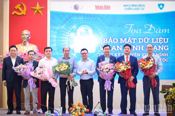 Đồng chí Lê Quốc Minh, Ủy viên Ban Chấp hành Trung ương Đảng, Tổng Biên tập Báo Nhân Dân, Phó trưởng Ban Tuyên giáo và Dân vận Trung ương, Chủ tịch Hội Nhà báo Việt Nam tặng hoa các diễn giả của buổi tọa đàm. Ảnh: THÀNH ĐẠT