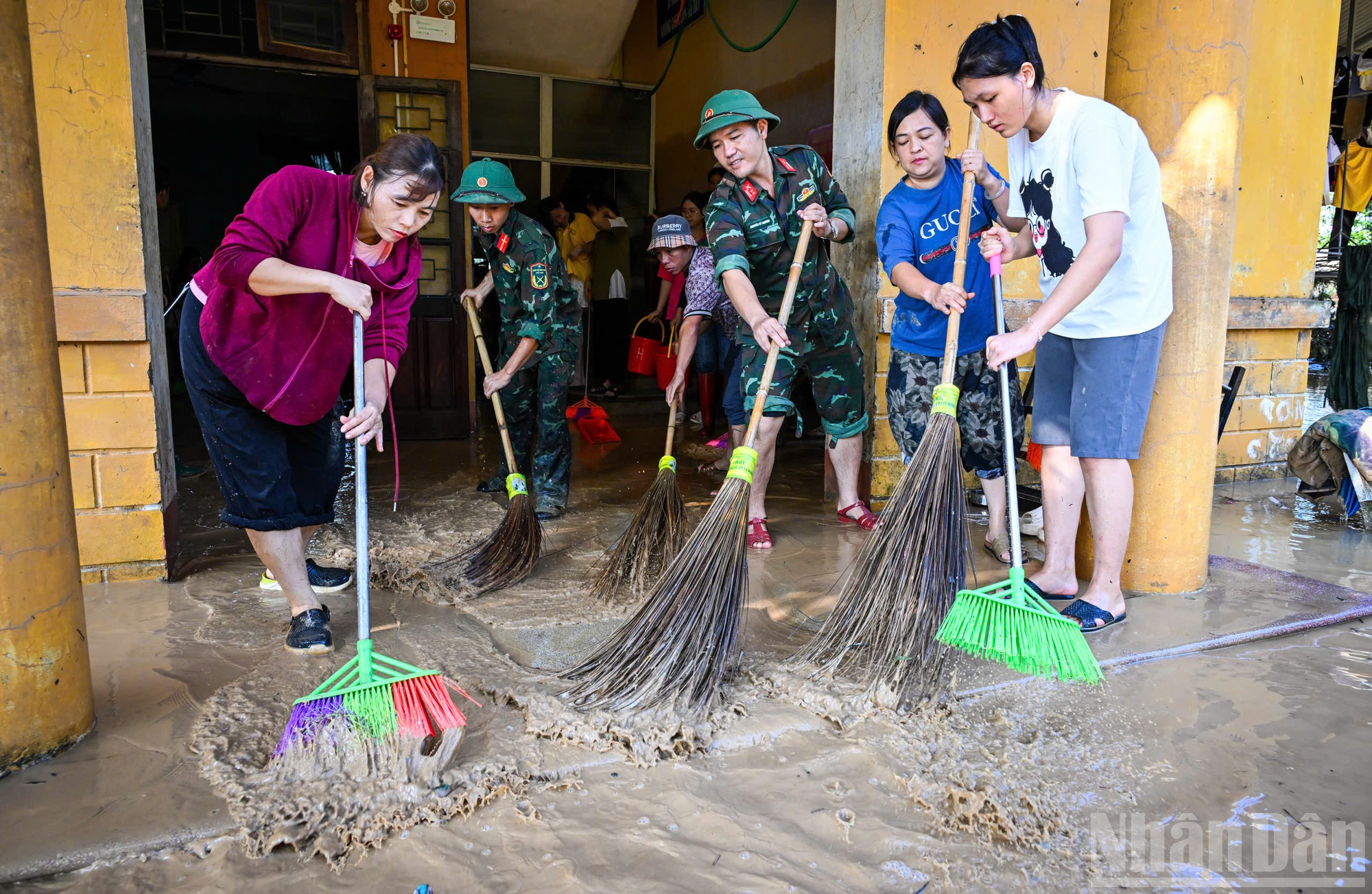Cán bộ, chiến sĩ Trung đoàn 12 cùng giáo viên nhà trường dọn bùn đất trong các phòng học sau khi nước lũ rút. ndo_br_z7101324048813-c5873266a5fed1da41e21a43014ed286.jpg