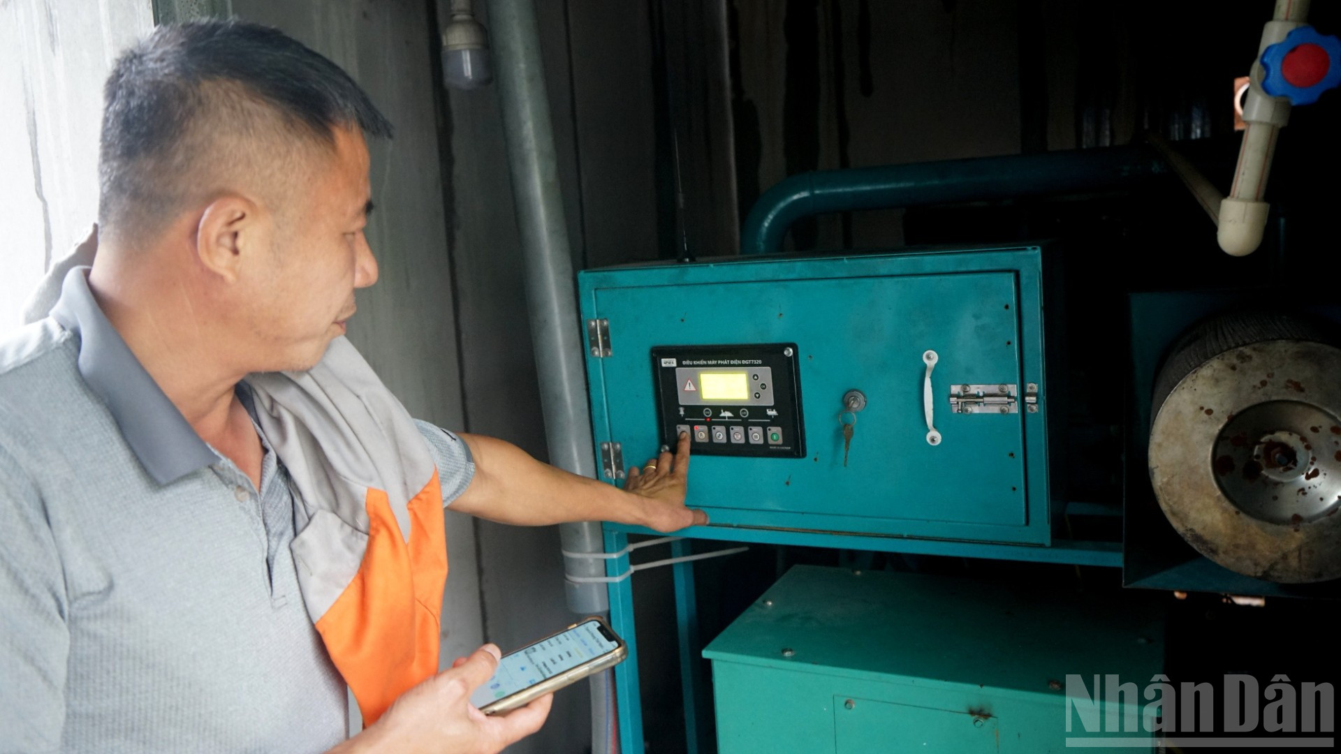 Ông Trần Xuân Phong vận hành máy phát điện từ khí biogas. (Ảnh: TRUNG HƯNG)