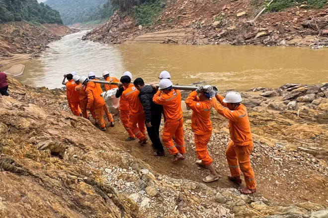 Công nhân vận chuyển máy móc, thiết bị vượt ghềnh đá để xuống thuyền, sau đó vượt qua quãng sông dài với nhiều đoạn thác nguy hiểm để đến được bản.