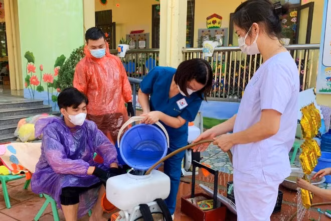 Cán bộ y tế phun hóa chất tiêu độc, khử trùng ở những nơi bị ngập lụt.