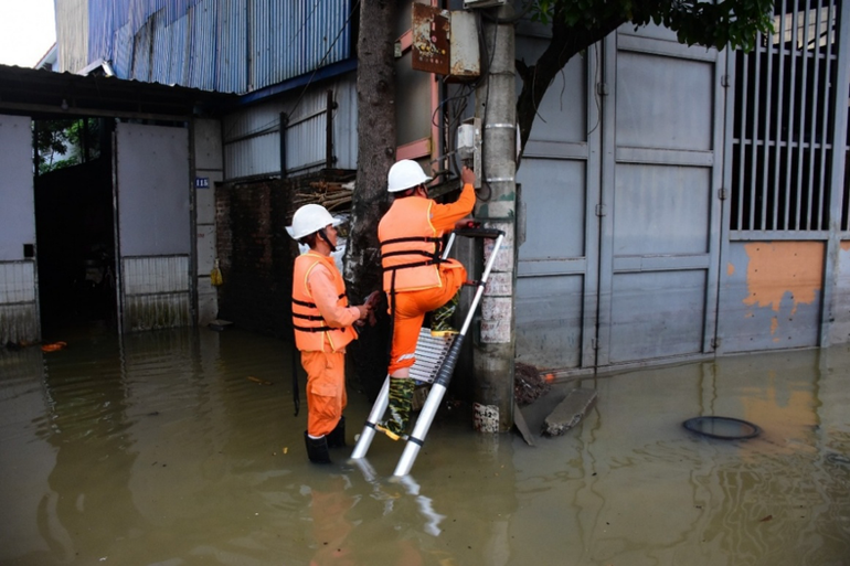 Công nhân EVNHANOI kiểm tra thiết bị điện tại khu vực ngập úng thuộc xã Trung Giã, thành phố Hà Nội. img-8110.png