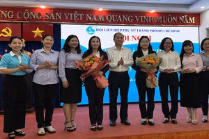 Đại diện Thành ủy và Ủy ban nhân dân thành phố tặng hoa chúc mừng bà Nguyễn Thị Ngọc Xuân (thứ tư từ phải sang).