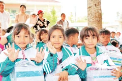 Các em học sinh tiểu học vui mừng vì có áo mới, sách vở mới do Tỉnh đoàn Khánh Hòa hỗ trợ.