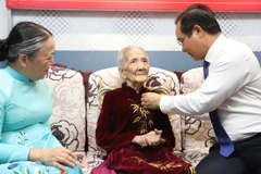 Chủ tịch Ủy ban nhân dân Thành phố Hồ Chí Minh Nguyễn Văn Được trao Huy hiệu 80 năm tuổi Đảng cho đảng viên Trần Thị Kim Anh.