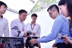 Các nhà đầu tư và thanh niên tham quan gian hàng trình diễn sản phẩm khởi nghiệp đổi mới sáng tạo về khoa học-công nghệ tại một triển lãm do Thành Đoàn Hà Nội tổ chức.