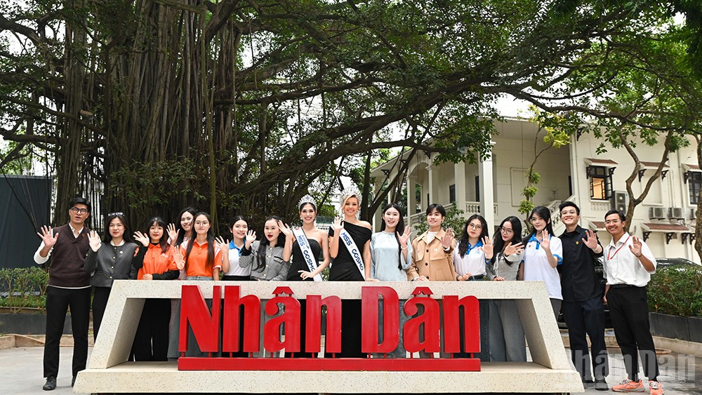 Top 2 Miss Cosmo chụp ảnh lưu niệm cùng các sinh viên tham gia buổi giao lưu tại Báo Nhân Dân. (Ảnh: THẾ ĐẠI)