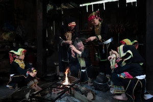 Bà Bàn Minh Toan cùng các phụ nữ Dao Lù Gang quây quần bên bếp lửa thực hiện công đoạn sơn đầu, trong không gian sinh hoạt đậm chất cộng đồng.