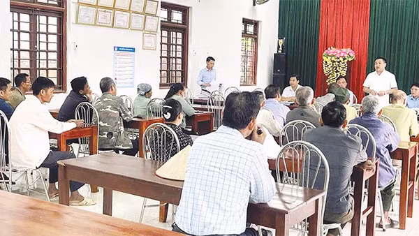 Cán bộ xã đối thoại với người dân có đất được thu hồi để triển khai dự án điện.