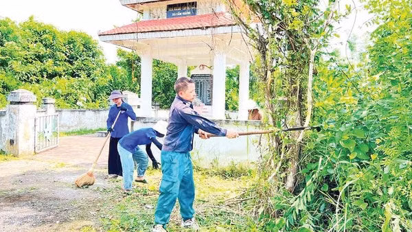 Anh Triệu Văn Nam, Bí thư Chi bộ, Trưởng thôn Nà Tu, xã Cẩm Giàng cùng đoàn viên, thanh niên vệ sinh Đài tưởng niệm liệt sĩ xã (Ảnh TUẤN SƠN)