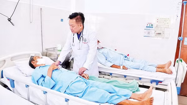 Tiến sĩ, bác sĩ Nguyễn Duy Tân thăm hỏi bệnh nhân Võ Hoành sau ca mổ.