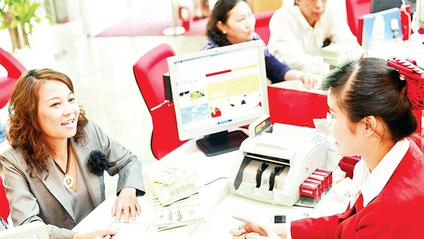 Giao dịch vay vốn tại một ngân hàng thương mại ở Thành phố Hồ Chí Minh. (Ảnh THẾ ANH)