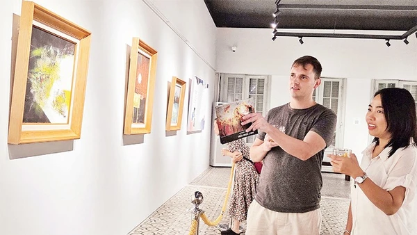 Khách xem tranh trong trưng bày chuyên đề "Trở về" tại Bảo tàng Mỹ thuật Thành phố Hồ Chí Minh. (Ảnh ĐÔNG A)