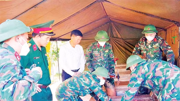 Lực lượng quân sự khai quật mộ phần tại Nghĩa trang liệt sĩ Đình Lập để tiến hành lấy mẫu (Ảnh DƯƠNG NGUYÊN)