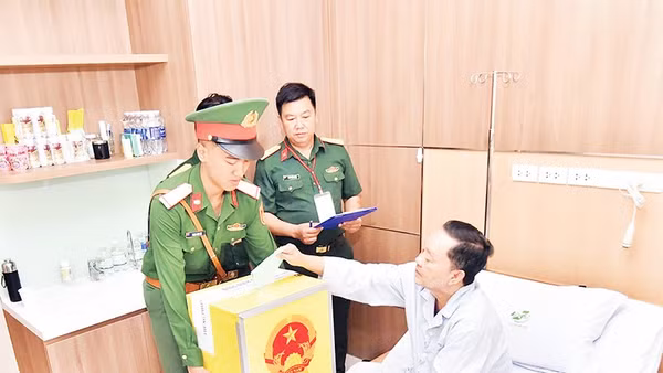 Bệnh nhân Bệnh viện Quân y 175 bỏ phiếu vào thùng phiếu di động. (Ảnh TÙNG LÂM)