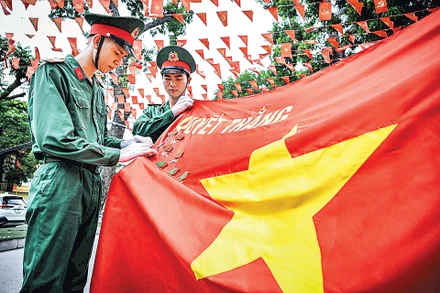 Các chiến sĩ tiêu binh danh dự cài huy chương trên Quân kỳ quyết thắng. (Ảnh: THÀNH ĐẠT)