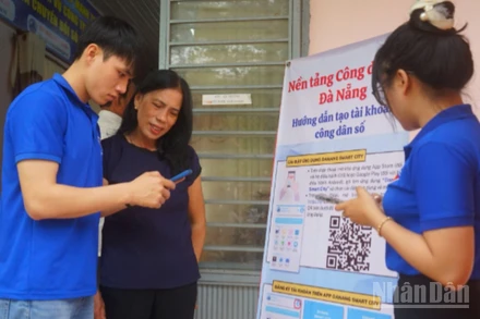 Thanh niên tình nguyện hướng dẫn người dân cài đặt ứng dụng Danang smart city.