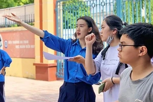 Tình nguyện viên quận Tây Hồ dẫn đường cho thí sinh vào phòng thi.