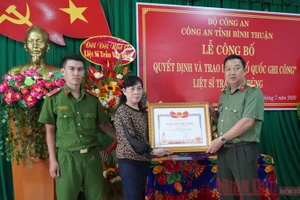 Gia đình Liệt sĩ Trần Văn Dũng (vợ và con trai bên trái) nhận Bằng “Tổ quốc ghi công”.
