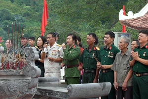 Các cựu binh cùng hòa giọng "Về đây đồng đội ơi" trước đài hương 468. Ảnh: TÀI VĂN