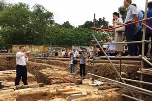 Các nhà khoa học khảo sát hiện trường hố khai quật khảo cổ. 