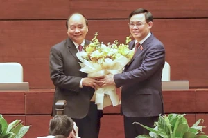 Chủ tịch Quốc hội Vương Đình Huệ tặng hoa, chúc mừng đồng chí Nguyễn Xuân Phúc. (Ảnh: ANH HUY)