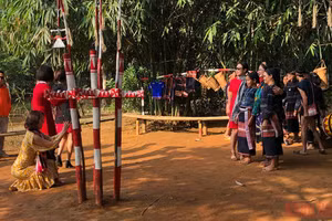 Du khách chụp ảnh với đồng bào dân tộc tại Làng Văn hóa.