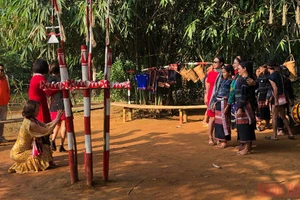 Du khách chụp ảnh với đồng bào dân tộc tại Làng Văn hóa.