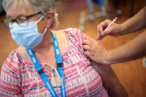 Một phụ nữ người Anh được tiêm liều vaccine tăng cường. Ảnh: Reuters.