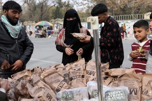 Người dân Afghanistan mua thực phẩm từ một gánh hàng rong ở Kabul, Afghanistan ngày 17/11/2021. (Ảnh: Reuters)