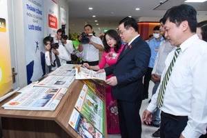 Chủ tịch Quốc hội Vương Đình Huệ xem các ấn phẩm của báo Đại biểu Nhân dân. (Ảnh Duy Linh)