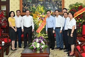 Bí thư Thành ủy Đinh Tiến Dũng tặng hoa chúc mừng Báo Nhân Dân nhân Ngày Báo chí cách mạng Việt Nam. (Ảnh: DUY LINH)