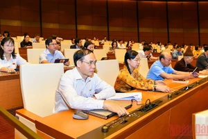 Đại biểu Quốc hội bấm nút biểu quyết thông qua Nghị quyết về phê chuẩn quyết toán ngân sách nhà nước năm 2020. (Ảnh: LINH KHOA NGUYÊN)