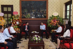 Bộ trưởng Thông tin và Truyền thông Nguyễn Mạnh Hùng chúc mừng lãnh đạo, cán bộ Báo Nhân Dân. (Ảnh: TRẦN HẢI)