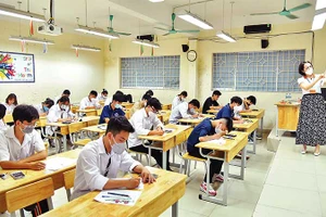 Giám thị hướng dẫn cách làm bài thi môn Toán tại điểm thi Trường THPT Nguyễn Gia Thiều, thành phố Hà Nội. (Ảnh: MỸ HÀ)