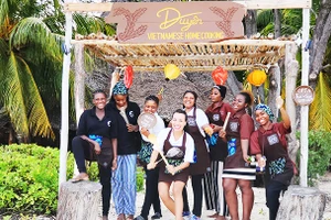 Kim Anh (hàng đầu) cùng nhân viên địa phương trước cổng nhà hàng.