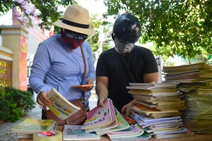 Chị Anh Hà (trái) lựa sách cho em Hoàng Long.