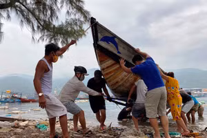 Lực lượng chức năng giúp người dân kéo tàu thuyền vào bờ, tránh bão số 5, sáng ngày 17-9.