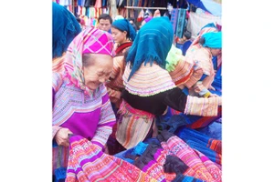 Bán thổ cẩm ở chợ Si Ma Cai. Ảnh: TUẤN LỢI