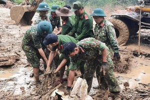 Lực lượng chức năng nỗ lực tìm kiếm nạn nhân còn mất tích tại làng ông Đề.