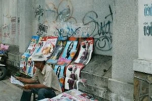 Một mảng tường trên đường Nguyễn Thị Minh Khai bị bôi bẩn vì số điện thoại và hình vẽ kỳ dị.