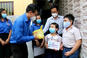 Ðoàn Thanh niên TP Hồ Chí Minh tặng máy tính bảng trong chương trình "Tuổi trẻ EVN thắp sáng niềm tin" cho trẻ mồ côi do dịch Covid-19 ở Quận 4. (Ảnh TTXVN)