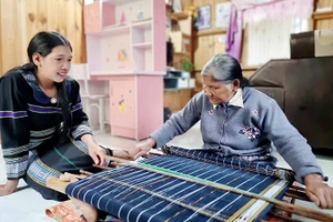 Nghệ nhân Ưu tú Ka Glòng ở Đưng K'Nớ truyền nghề cho con gái.