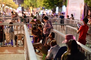 Người dân xếp hàng đợi từ tối 20/5 đế nhận vé xem trận chung kết bóng đá nữ giữa Việt Nam và Thái Lan vào tối 21/5. (Ảnh: Thanh Vân/TTXVN)