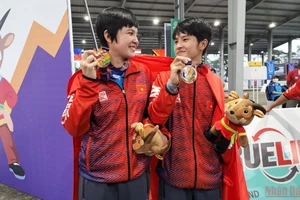 Thái Thị Hồng Thoa (bên trái) hạnh phúc với tấm Huy chương Vàng bộ môn bi sắt nội dung đôi nữ. (Ảnh: SƠN BÁCH)