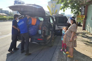 Nhóm tình nguyện viên giúp gia đình chị Loan sắp xếp đồ để trở về quê.